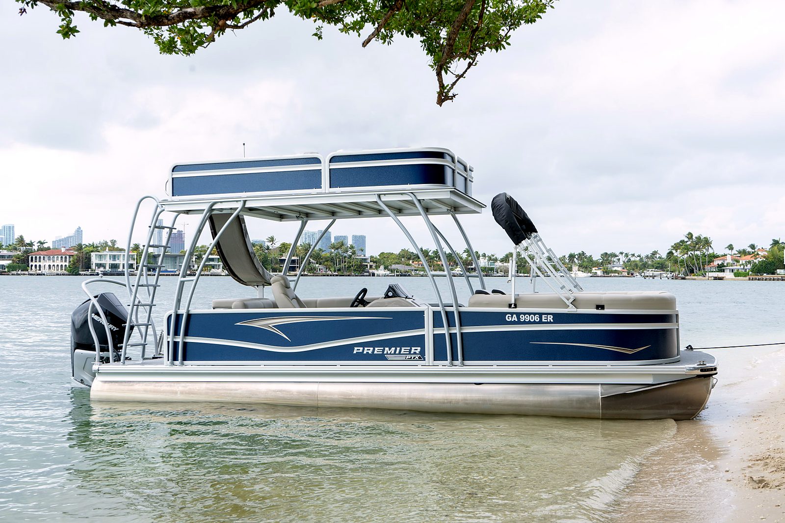 Side profile of the double-deck tritoon with waterslide at the beach